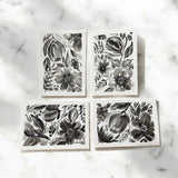 Hand-painted 5x7-inch greeting card featuring layered black watercolor florals on textured white paper, with matching painted motifs on the envelope and interior.