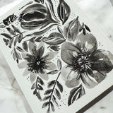 Hand-painted 5x7-inch greeting card featuring layered black watercolor florals on textured white paper, with matching painted motifs on the envelope and interior.