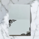 Hand-painted 5x7-inch greeting card featuring layered black watercolor florals on textured white paper, with matching painted motifs on the envelope and interior.