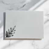 Hand-painted 5x7-inch greeting card featuring layered black watercolor florals on textured white paper, with matching painted motifs on the envelope and interior.