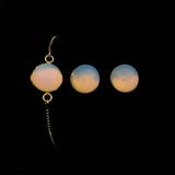 Image of opalite bracelet and matching stud earrings on a black background.