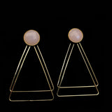 Image of faceted pale pink earrings with two, thin gold plated, overlapping triangles underneath, on a black background.