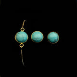 Image of turquoise bracelet and matching stud earrings on a black background.