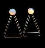 Image of opalite earrings with two, thin gold plated, overlapping triangles underneath, on a black background.